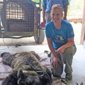 Charlotte Milling poses with an anaesthetized grizzly bear.